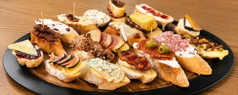 Bandeja de montaditos: pan del día con quesos, embutidos y encurtidos.