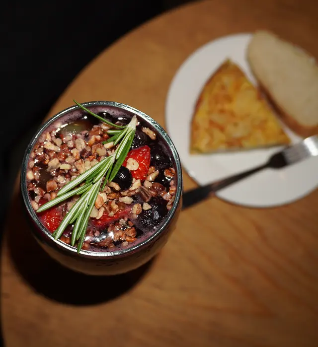 Postre de frutos rojos y una rebanada de tortilla, servidos al cierre de la noche.